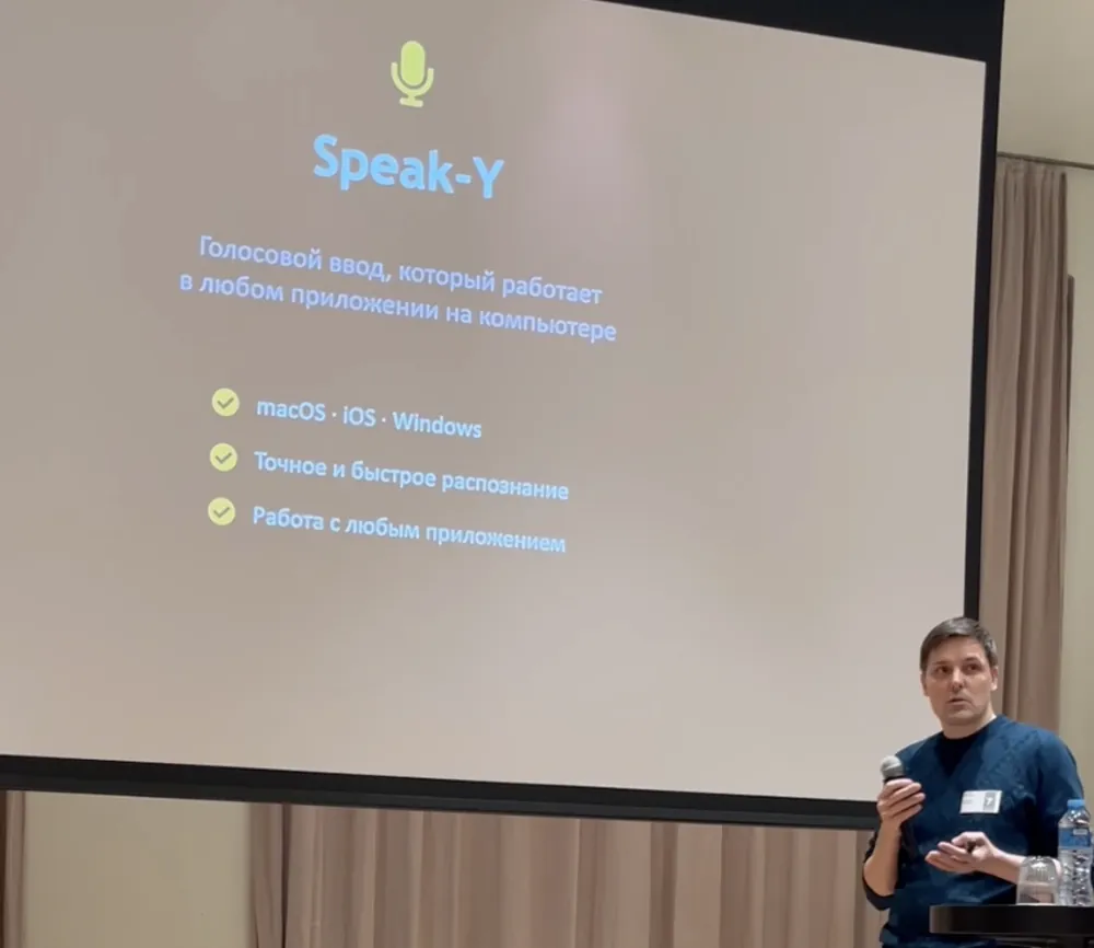 Aleksei Grebenkin presenting Speak-Y at the Co-Founder Meeting in Batumi, with a slide describing system-wide voice input for macOS, iOS and Windows